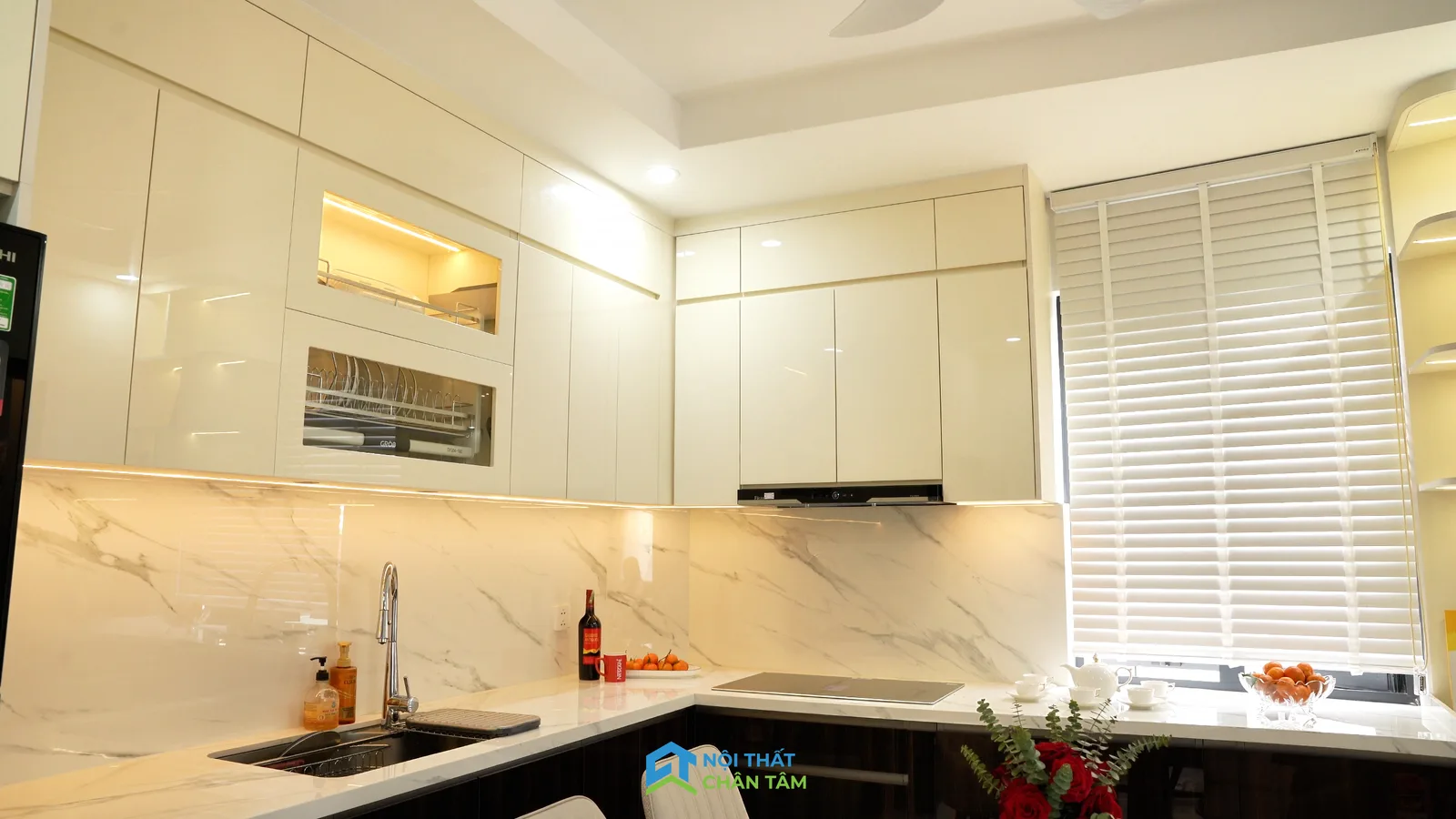 Khu bếp với tủ sáng màu và mặt bàn dưới tủ treo